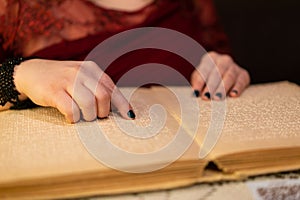 close-up of a woman's hand reading a braille book