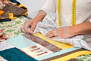 Close up of woman`s hand sewing patchwork