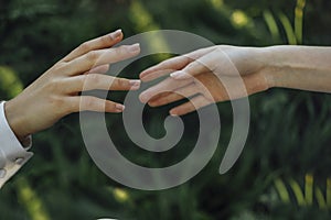 Close up of a woman`s hand touching the grass, feeling nature