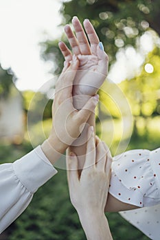 Close up of a woman\'s hand touching the grass, feeling nature