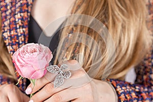 Close-up of woman& x27;s hand on tweed jacket holding flower