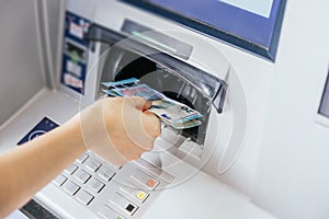 Close up of a woman`s hand withdrawing cash, euro bills from the ATM bank machine. Finance customer and banking service concept