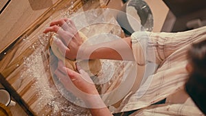 Close-up of a woman's hands , applying flour to the dough, a girl kneading the dough, baking a traditional recipe