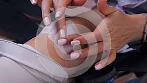 Close-up of a woman's hands applying a sterile surgical plaster to postoperative sutures. Knee injury. Self