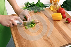 Close up of woman`s hands cooking in the kitchen. Housewife slicing fresh salad. Vegetarian and healthily cooking