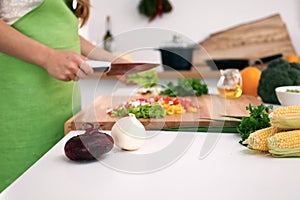 Close up of woman`s hands cooking in the kitchen. Housewife slicing fresh salad. Vegetarian and healthily cooking