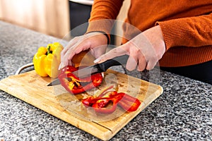 close-up of woman's hands cutting peppers on a cutting boardfresh