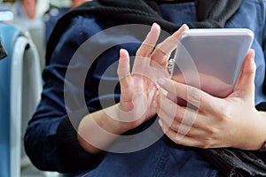 Close-up of a woman's hands holding and using a smartphone