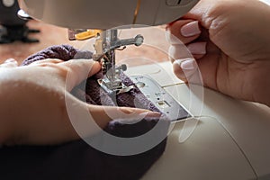 Close-up of a woman's hands sewing on a sewing machine
