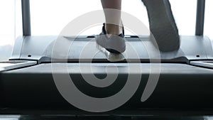 Close up woman`s legs on a treadmill in the gym