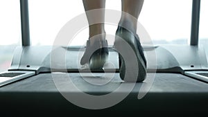 Close up woman`s legs on a treadmill in the gym