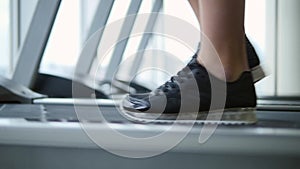 Close up woman`s legs on a treadmill in the gym