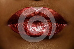 Close-up of woman's lips with bright fashion dark red glossy makeup. Macro lipgloss cherry make-up. kiss