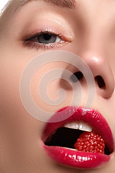 Close-up of woman`s lips with bright fashion red glossy make-up