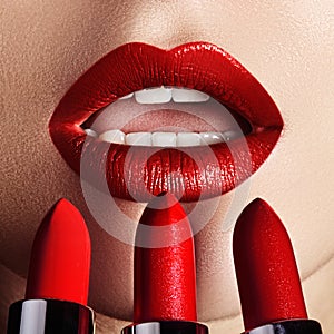 Close-up of woman`s lips with fashion red make-up. Macro shot of beautiful make up on full lips. Choice lipstick