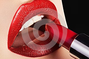 Close-up of woman`s lips with fashion red make-up. Macro shot of beautiful make up on full lips. Choice lipstick