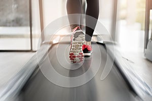 Close up of  woman`s muscular legs feet running on treadmill workout at fitness gym, Healthy lifestyle