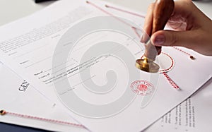 Close up on woman's notary public hand ink stamping the document photo