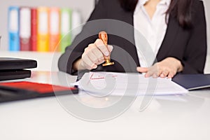 Close up on woman's notary public hand stamping the document