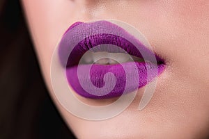 Close up of the woman`s open lips. Purple lipstick, lip gloss, cosmetics.