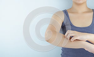 Close up woman scratching her itchy arm with allergy rash by hand on white background. Healthcare, skin problem and medical