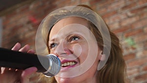 Close up. a woman screaming to a microphone. a woman sings karaoke into a microphone in a home setting. 4k, slow motion