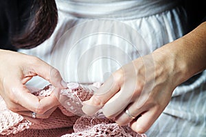 Close-up of a woman sews a button
