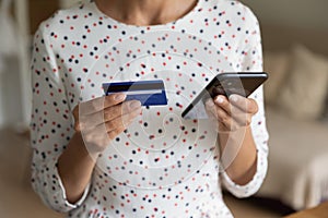 Close up of woman shopping on cellphone with credit card