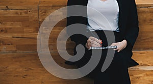 Close up woman sitting at cafe and writing on notebook