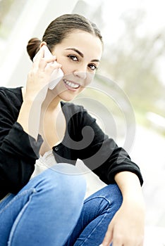 Close up of woman sitting with legs bent on phone