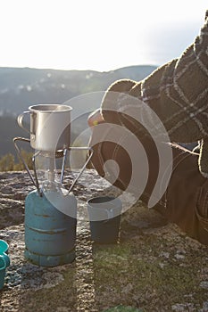 Close-up of woman sitting at mug on portable camp stove