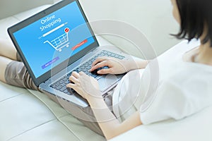 Close up woman sitting and shopping online on laptop computer in add to cart function photo