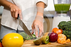 Close up of woman slicing vegetables for smoothie