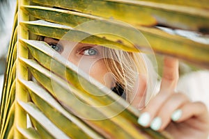 Close up of woman standing near palm tree