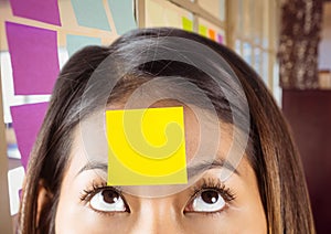 Close-up of woman with sticky note on her forehead