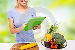 Close up of woman with tablet pc cooking at home