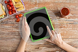 Close up of woman with tablet pc food on table