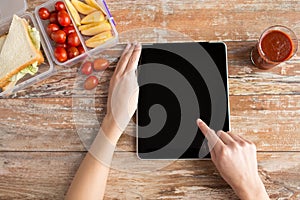 Close up of woman with tablet pc food on table