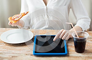 Close up of woman with tablet pc having dinner