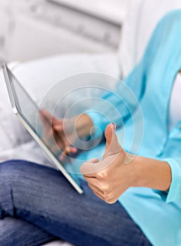 Close up of woman with tablet pc showing thumbs up