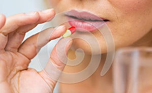 Close up of woman taking medicine in pill