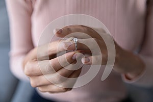 Close up woman taking off wedding ring, divorce concept