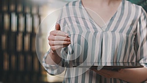 Close up, woman touching the tablet screen in flat position in her hands. background for futuristic effects