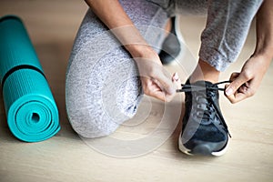 Close Up Of Woman Tying Laces Of Training Shoes Before Exercise At Home