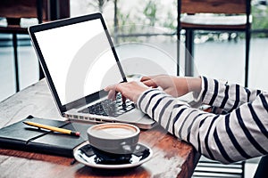 Close up woman type on laptop keyboard and looking at computer screen on table in coffee shop,Blank notebook screen mock up for
