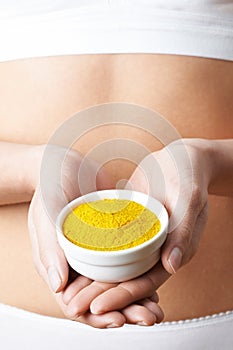 Close Up Of Woman In Underwear Holding Dish Of Tumeric