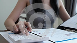 Close up woman using calculator and laptop for calaulating finance, tax, accounting, statistics and analytic research concept