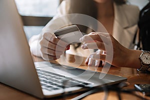 Close up woman using laptop and credit card for pay online shopping e-commerce online payment concept.