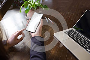 Close up of a woman using mobile smart phone on the table