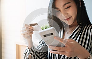 Close up woman using smartphone and credit card for pay online shopping e-commerce online payment concept.